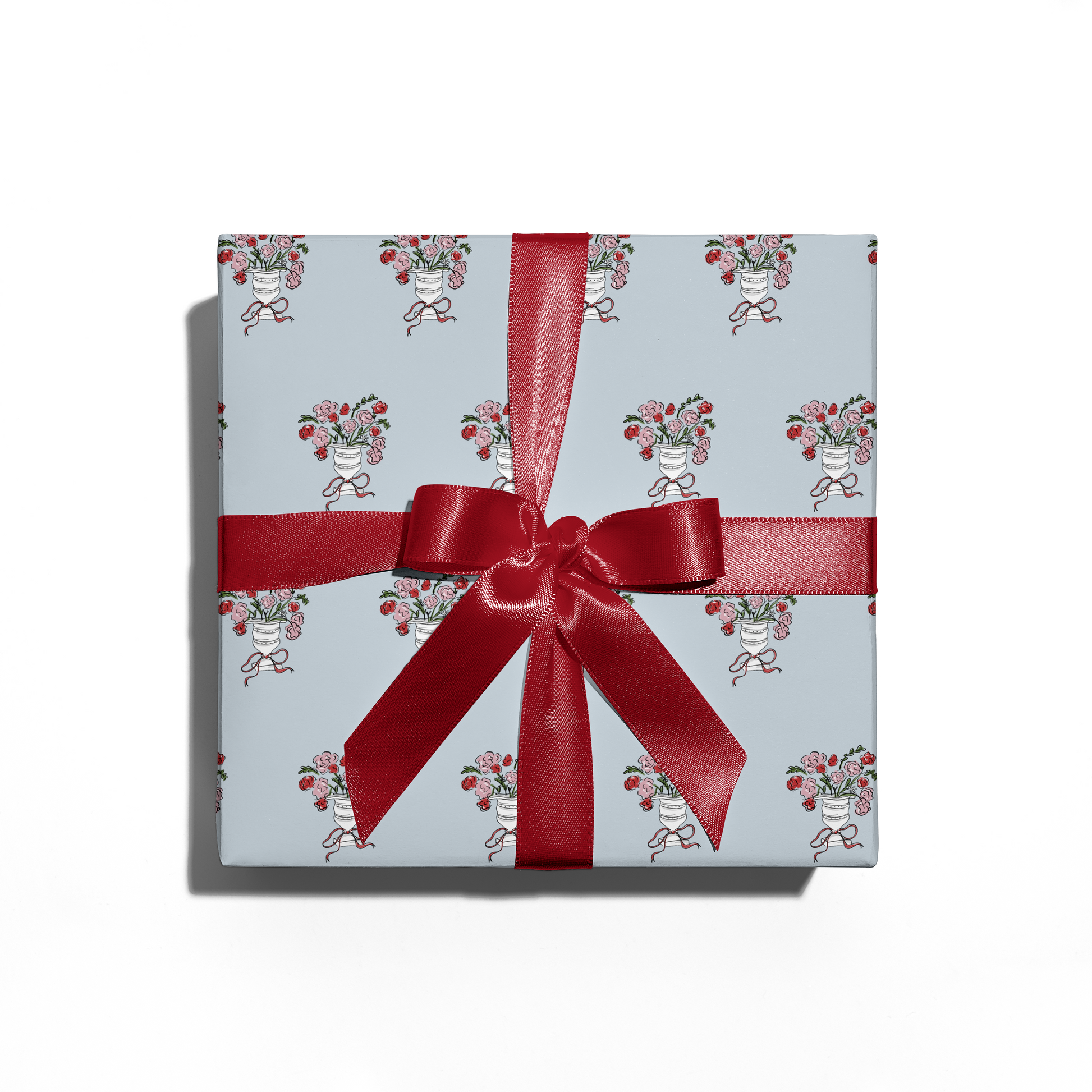 Gift box with floral pattern and red ribbon on a white background