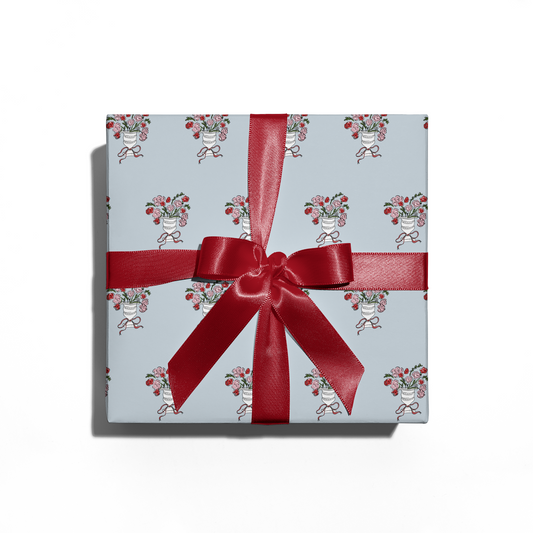 Gift box with floral pattern and red ribbon on a white background